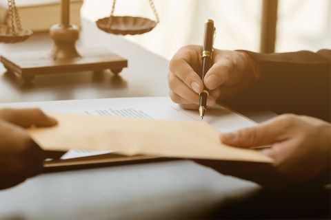 Foto: Person unterschreibt Dokument